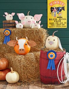 hay bales filled with fake farm animals and pumpkins