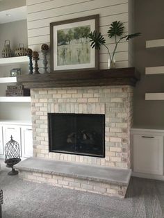 a living room with a fire place and shelves on either side of the fireplace,