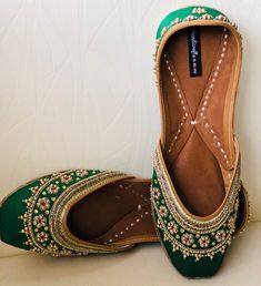 'GRACEFUL GREEN' is an extraordinary jutti intricately hand embroidered by our finest artisans. Green silk base with delicate kundan beads, zardosi work and gold dabka strings in the front and on the back. Like its name, it's elegant, timeless and graceful! PERFECT FOR ANY OCCASION AND ANY OUTFIT!! *Ethnic Shoes/Women Flats/Handmade Indian Designer Women Shoes or Slippers/Royal shoes/traditional style Women/Wedding Shoes/Bridal Shoes, Punjabi Jutti for Women SPECIFICATIONS: *Upper/Panna -Fabric Green Closed Toe Flats For Party, Traditional Green Wear For Reception, Green Traditional Wear For Reception, Festive Gota Work Wedding Shoes, Flat Wedding Shoes With Cutdana For Festivals, Festive Meenakari Flats With Round Toe, Traditional Flat Wedding Shoes For Festivals, Flat Wedding Shoes For Receptions And Festivals, Flat Wedding Shoes For Reception