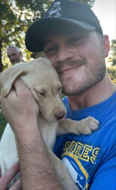 a man holding a puppy in his arms