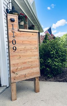 a wooden sign sitting on the side of a house