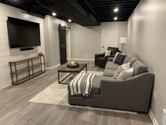 a living room filled with furniture and a flat screen tv mounted on the wall above it