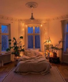 a bed room with a neatly made bed and lots of plants on the windowsill