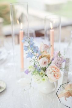 a white table topped with flowers and candles