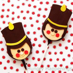 there are two cake pops shaped like people wearing hats on top of each other and one has a toothpick in the shape of a man's head