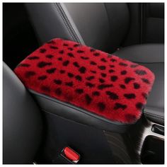 the interior of a car with a red and black animal print seat cover on it