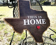 a wooden sign that says, this is home with a heart in the shape of texas