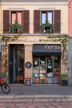 a bike parked in front of a store on the side of a street next to a building