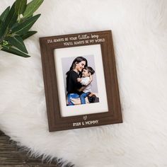 a mother holding her baby while she holds the child in her arms with an inscription on it