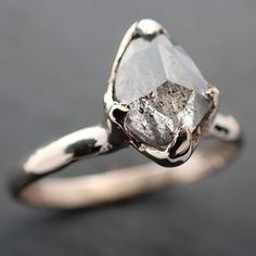 a close up of a diamond ring on a black surface with the stone in it's center