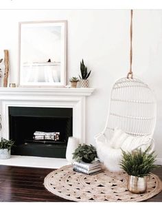 a living room filled with lots of potted plants next to a white fire place