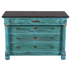 an old blue dresser with black marble top