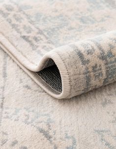 an area rug with a blue and white design on it, laying on the floor