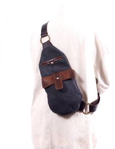 Our handbags are handcrafted with the highest quality materials, to create a beautiful and durable product. This black and brown sling bag is unique. Handmade from strong canvas and leather, it has a zippered back pocket and an inner pocket to hold all your valuables. With magnetic clasps on the hood flaps and an adjustable metal buckle on the strap, this one strap backpack is super comfy and perfect for every day use. Stainless steel fastener. Plated all-brass grommets. This bag is made to be u On-the-go Black Shoulder Bag With Waxed Finish, Black Shoulder Bag With Waxed Finish For On-the-go, Black Waxed School Bag, Black Waxed Finish Shoulder Bag, Black Shoulder Bag Backpack With Leather Trim, Black Leather Trim Backpack Shoulder Bag, Black Waxed Finish Backpack, Black Saddle Bag With Leather Trim For Travel, Black Waxed Crossbody Bag