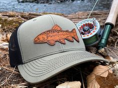 Custom Brook Trout Leather Patch Hat. This trucker style hat is perfect to add your personalized touch to. Choose from our variety of hat color and leather color options. Fish patch engraved into our high quality leather patch hat. PRODUCT DETAILS -------------------------- ~ Richardson 112 trucker style snapback hats ~ Brook Trout on our high quality 100% genuine leather patch hats ~ Hat Color Options: Black, Navy, Heather Grey / Black, Charcoal / White, Navy / White, Charcoal / Black, Black / Curved Brim Trucker Hat For Fishing, Brown Fishing Cap, Adjustable Trucker Hat For Fishing, Brown Curved Brim Trucker Hat For Fishing, Brown Snapback Trucker Hat For Fishing, Brown Snapback Fishing Hat, Brown Snapback Hat For Fishing, Brook Trout, Fishing Hat