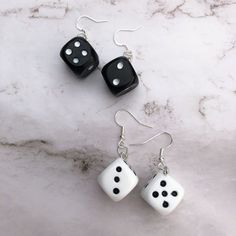 black and white dice earrings on marble background