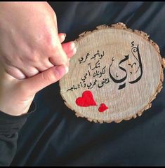 a person holding a piece of wood with writing on it