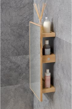 a wooden shelf with two bottles on it and soaps in the bottom one is open