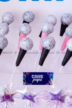 cake pops are lined up on sticks with pink and silver decorations in the shape of stars