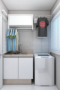 a small laundry room with clothes hanging on the rack