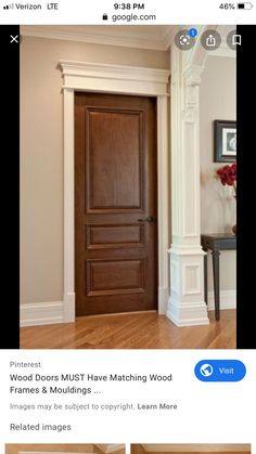 a wooden door is in the middle of a room with white trim and wood floors