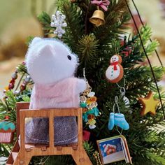 a stuffed animal sitting on top of a wooden chair next to a christmas tree