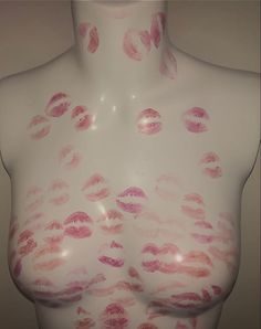 a white mannequin with pink and red lipstick on it's breast area