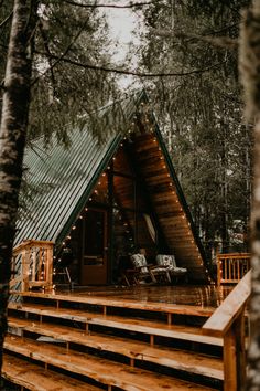 a small cabin in the woods with stairs leading up to it