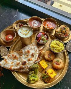 a plate with different types of food on it, including pita bread and vegetables