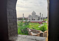 an open window looking out at the tajwa mosque in india, with people walking around