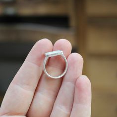 a person holding a silver ring in their hand