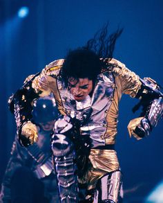 michael jackson performing on stage with his hands in the air as he rides a motorcycle