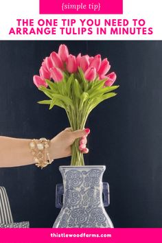 a person holding a vase with flowers in it and text overlay that reads, the one tip you need to arrange tulips in minutes