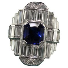 Beautiful Vintage Art Deco Platinum Baguette Diamond and Sapphire Cocktail Ring - GIA. This gorgeous Art Deco cocktail ring is crafted in platinum. The center holds a natural royal blue sapphire that has a GIA report and has white baguette cut diamonds and trillion cut diamonds set all of the top. The ring looks like a sheet of mirror and extremely sparkly! The ring is in great condition and has a serial number inside the shank. This is a remarkable ring and very rare to come by! Item #R1733 Metal: Platinum Weight: 11 Grams Size: 5 3/4 Diamonds: Approximately 4.5 cts Color: H Clarity: VS2 Sapphire: 1.87 ct - GIA # 1182009392 Measurements: Top of the ring measures 21.9 mm wide and band measures 1.75 mm wide. Measurements off the finger: 7.44 mm high Layaway: For your convenience, we will be Antique Rings 1stdibs, Wide Band Diamond And Sapphire Rings, Vintage Jewelry Rings 1stdibs, Art Deco Cocktail, Sapphire Cocktail Ring, Cocktail Art, Jewels Rings, Baguette Cut Diamond, Art Deco Diamond