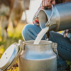 a person pouring water into a metal pot