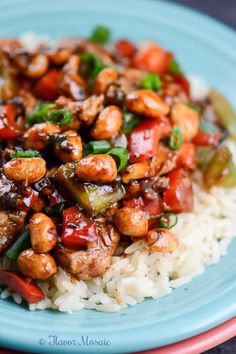 a blue plate topped with rice covered in meat and veggies on top of it