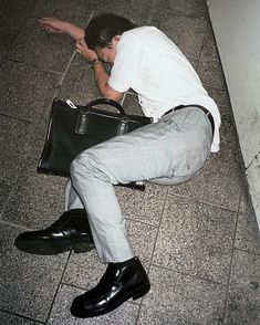 a man sitting on the ground with a briefcase