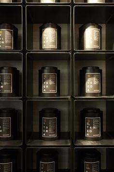 many black containers are arranged in rows on the wall, with numbers printed on them