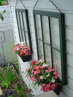 three flower pots hanging from the side of a house