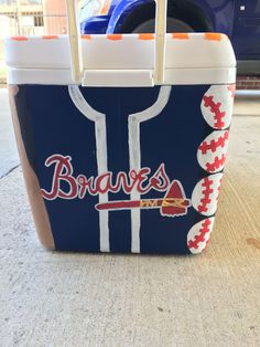 a cooler with the word braves painted on it and baseballs in red, white and blue