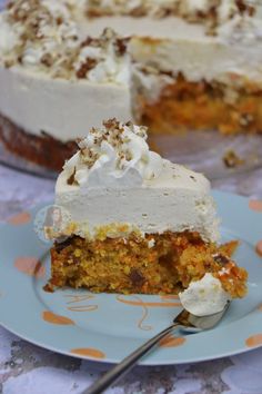 a piece of carrot cake on a plate with a fork in front of the cake