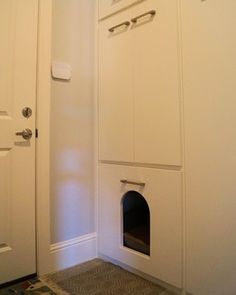 a dog house built into the side of a wall with a cat door and litter box