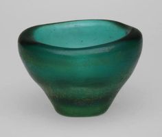 a green glass bowl sitting on top of a table