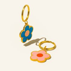 two keychains with flowers on them sitting next to each other in front of a white background