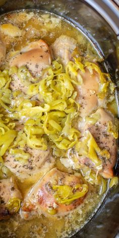 a pot filled with chicken and vegetables on top of a stove