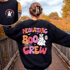 Pediatric Boo Crew Halloween Shirt, Custom Name Pediatric Nurse Halloween, Halloween Peds Nurse Shirt, Peds Crew, Nursing Halloween Shirt We've got all this and more: - Tshirt material: cotton, polyester - Sweatshirt material: cotton, polyester - Hoodie material: fleece fabric, heavy blend Production and Shipping - Processing Time: 3-5 business days - Shipping time (US): 3-5 business days - Shipping time (WW): 10-15 business days Note - Manual measurement may exist a 1-2cm difference - Actual co Fun Long Sleeve Halloween T-shirt, Playful Crew Neck Tops For Halloween, Black Themed Long Sleeve T-shirt, Nurse Attire, Peds Nurse, Nurse Halloween, Pediatric Nurse, Boo Crew, Halloween Nurse