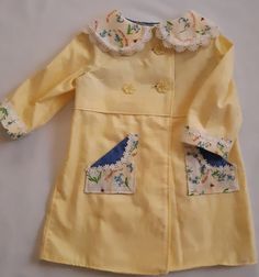 This gorgeous coat is made from vintage yellow damask and comes in a size 2. It is the matching coat to a delightful vintage dress (https://www.etsy.com/your/shops/LittleLarkClothing/tools/listings/791702327) This coat has vintage cotton lace trimming and pockets on the front made from the fabric of the matching dress. It is the most adorable matching outfit, and one-of-a-kind in a size 2. The coat is inspired by Princess Charlotte's wardrobe and any little girl who is lucky enough to wear it wi Spring Costume Outerwear With Long Sleeves, Handmade Long Sleeve Spring Dresses, Handmade Long Sleeve Dresses For Spring, Cute Spring Outerwear With Buttons, Spring Cream Outerwear With Covered Buttons, Handmade Fitted Vintage Dress, Vintage Long Sleeve Dress For Dress-up, Vintage Long Sleeve Dresses For Dress-up Occasions, Yellow Button Closure Dress For Fall