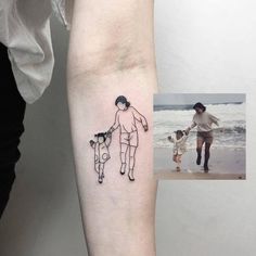 a man and woman walking along the beach with their dog tattoo on his left arm