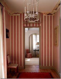 a hallway with striped walls and a chandelier