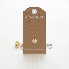 This necklace features a luminous 12mm Mother of Pearl hexagon as a honeycomb with a tiny bee. It hangs on an 18" vintage style beaded chain. The chain is 14k gold plated brass and coated to resist tarnish and create a hypoallergenic surface. Expertly crafted to last, this necklace showcases a radiant 12mm Mother of Pearl hexagon in the shape of a honeycomb with a delicate bee. The 18" chain boasts a vintage look and beaded design, constructed from 14k gold plated brass for a lustrous finish and Minimalist Gold Hexagon Necklace, Gold Hexagon Faceted Necklace, Hexagon Faceted Necklace For Gift, Hexagon Faceted Necklace For Gifts, Faceted Hexagon Necklace For Gift, Faceted Hexagon Necklace For Gifts, Sonoma California, Bee Necklace, Stunning Necklace